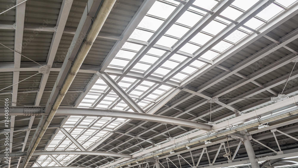 Gray and white metal roof structure in sunny day.