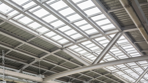 Gray and white metal roof structure in sunny day.