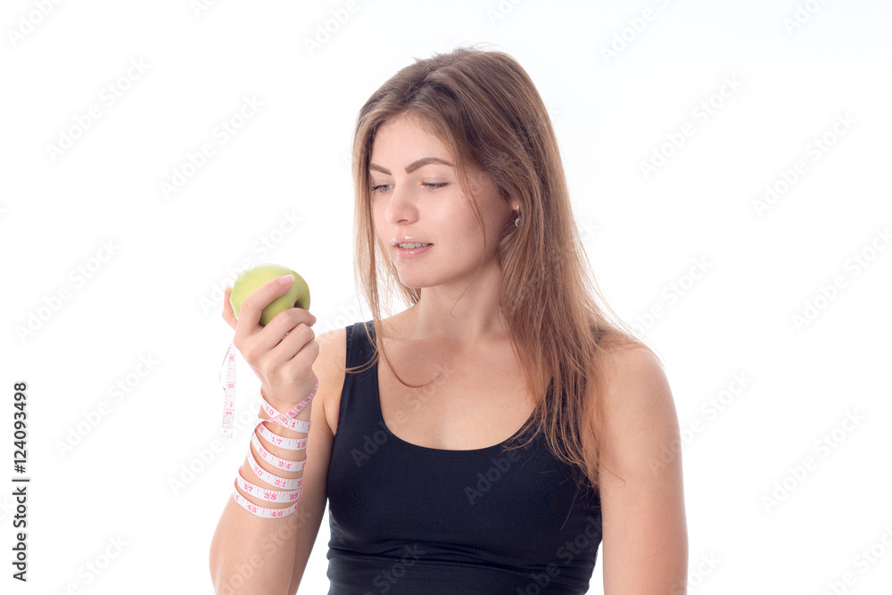 athletic girl standing sideways holding an apple in his hand athletic girl standing sideways holding an apple in his hand