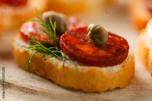 Crostini with different toppings on wooden background. Delicious appetizers. Front view. photo