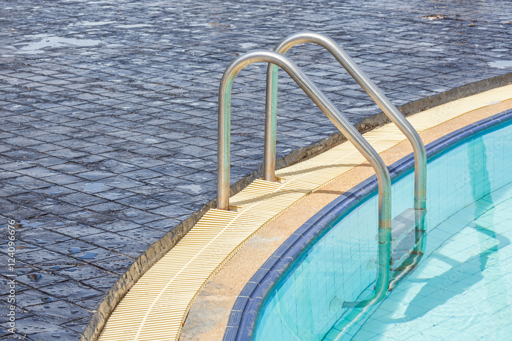 The metallic ladder for using entrance to swimming pool.
