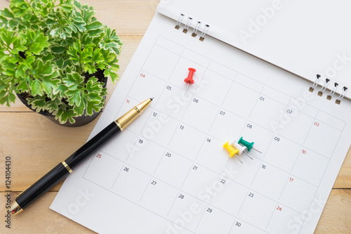 pen and accessories on calendar date with tree on wooden background