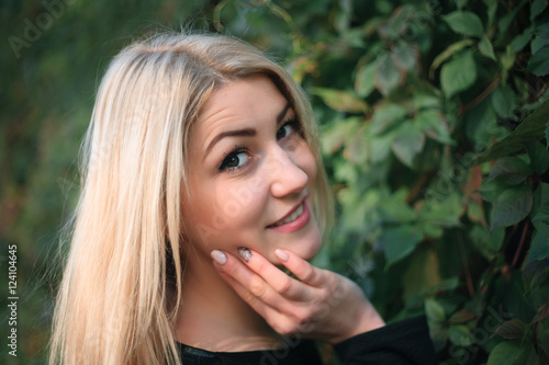 Attractive young woman on a background of ivy leaves