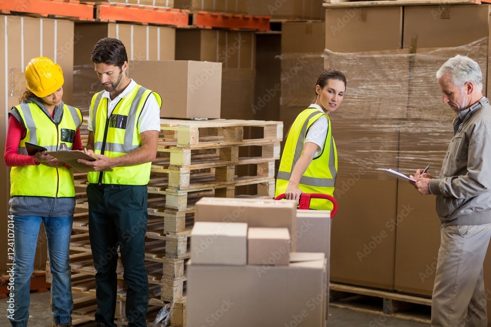 Warehouse manager and workers preparing a shipment Warehouse manager and workers preparing a shipment