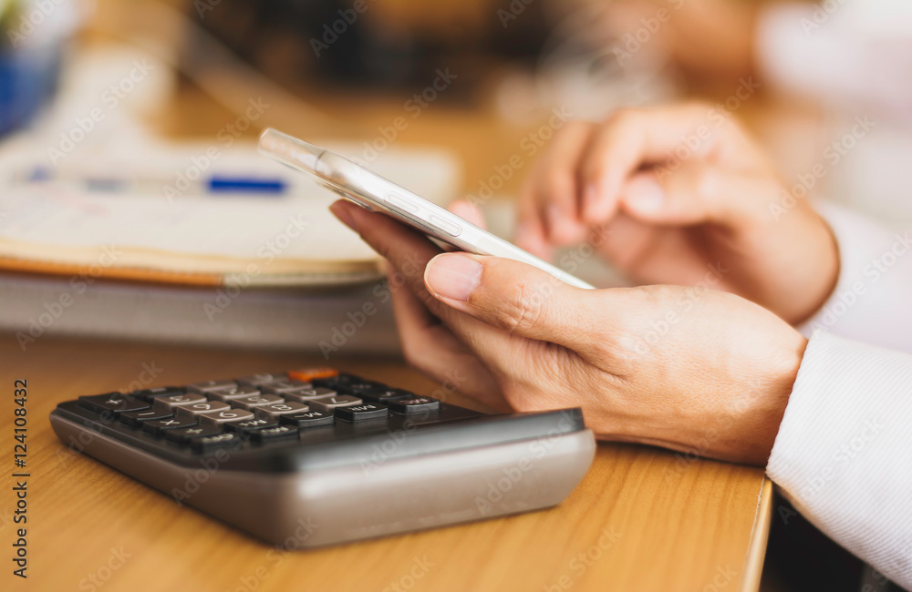 Fototapeta premium Selective focus view shot of a man's hands using smart phone in office, view of business man hands busy using cell phone at office desk, young male student typing 