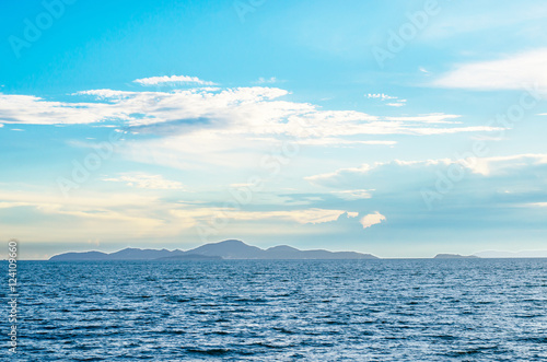 White fluffy clouds blue sky above a surface of the sea