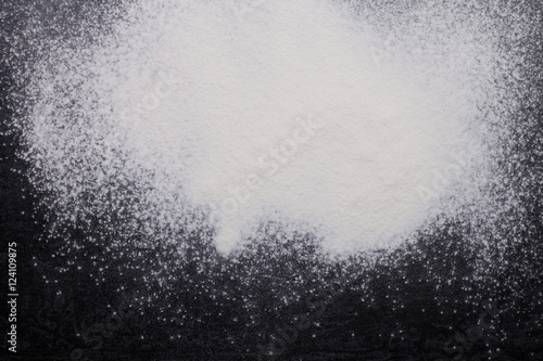 Flour spilling on black metal background
