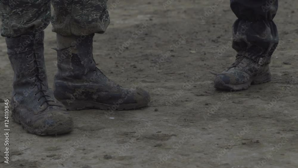 People stand in muddy boots. Dirty shoes and clothes People stand in muddy boots. Dirty shoes and clothes