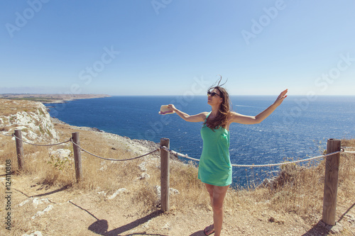 girl with green dress and hat in one hand, stands front view ful