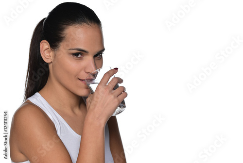 beautiful brunette woman holding and drinking glass of water. Isolated on white background