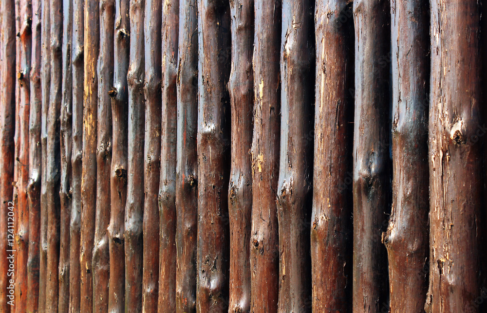 Wooden fence made of oak tree trunks. Focus is in the middle Wooden fence made of oak tree trunks. Focus is in the middle