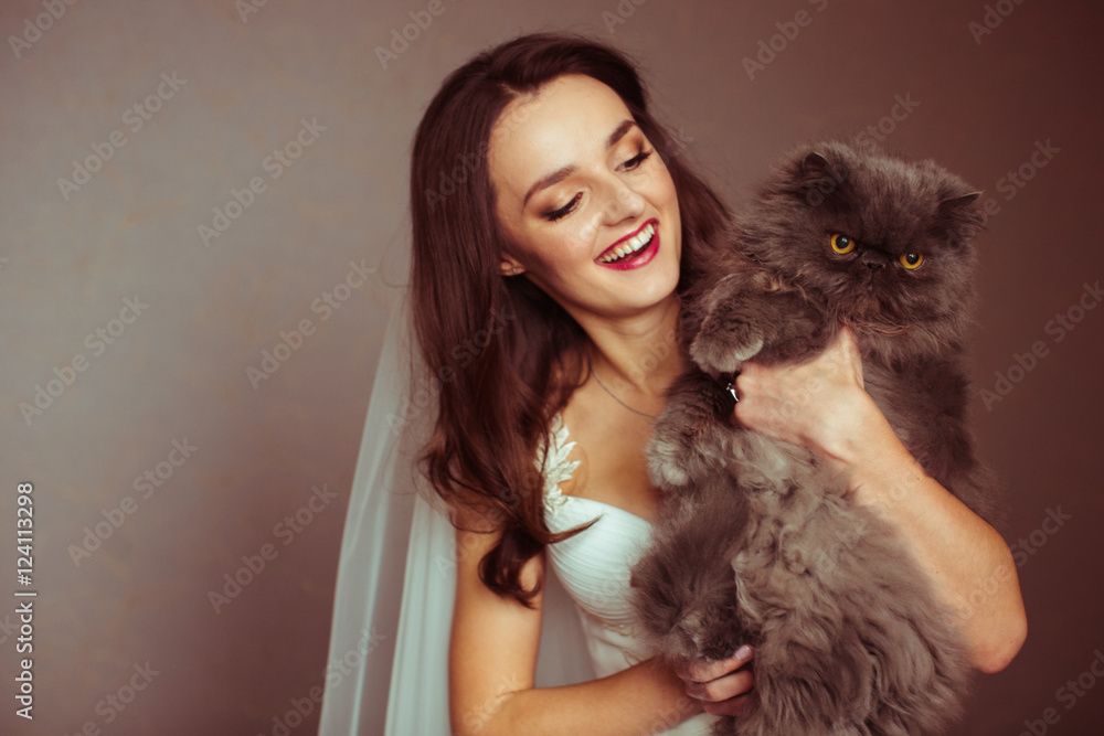 Attractive young bride holds a seious fluffy cat