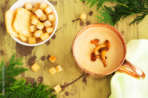 Chanterelle cream soup in coper mug served with croutons