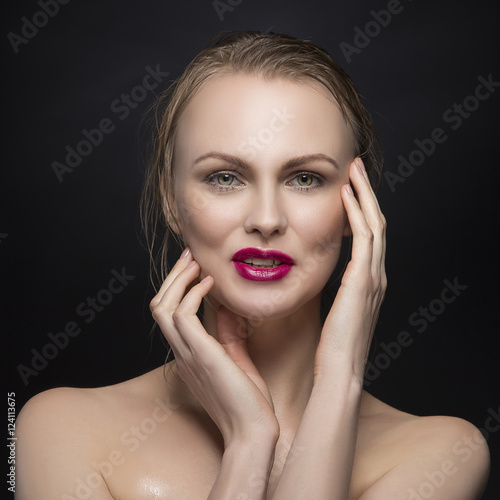 Beauty porrait of young blonde woman with a smile and red lipstick over black background