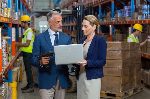 Warehouse manager and client using laptop