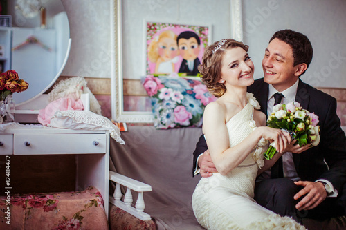 Charming smile illuminates bride's face while she sits with groo
