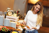 Attractive woman at breakfast buffet in hotel