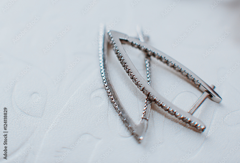 Silver earrings lie on the white background Silver earrings lie on the white background