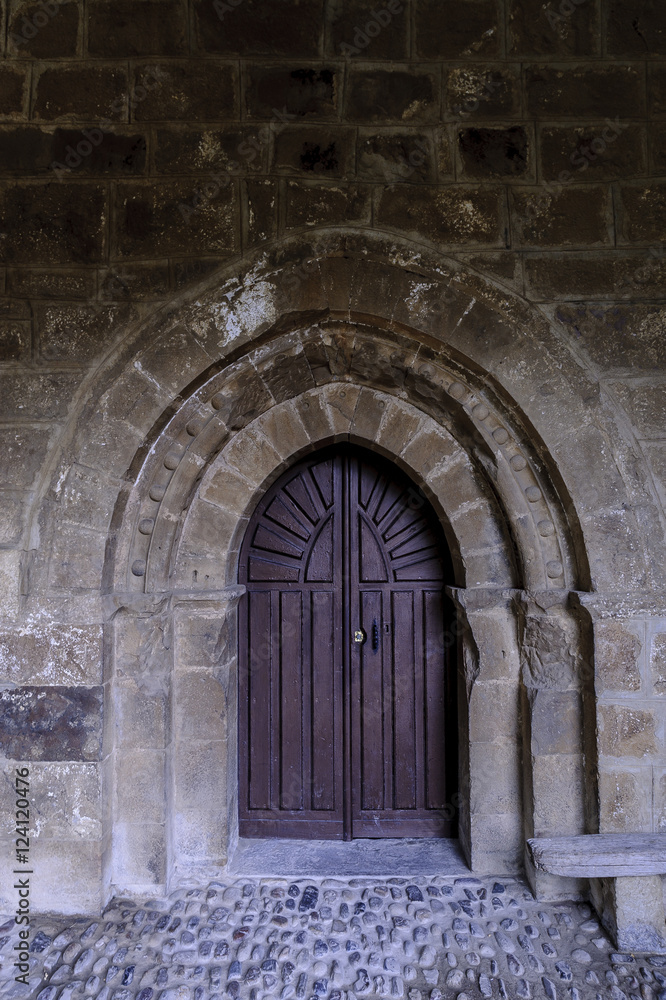 sight of the entry of the Romanesque collegiate church of San Salvador in Cantamuda in Palencia, Castile and León, Spain