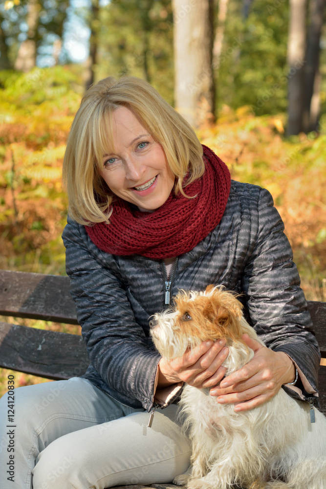 Reifere Frau mit Terrier genießt den Herbst Reifere Frau mit Terrier genießt den Herbst