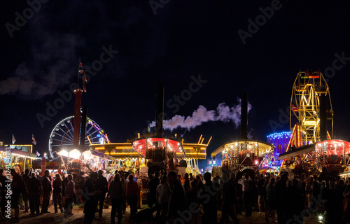 Carrousel, Steam and Ferriswheel at Steamfair England. Great Dorset steamfair at night. Fairground skyline at night.  Amusement park. photo