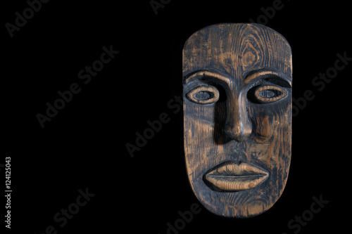 the mask is made of wood isolated on black background. free space for text