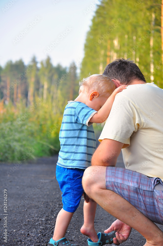 the father and the little son walk on a forest footpath. The fat the father and the little son walk on a forest footpath. The fat