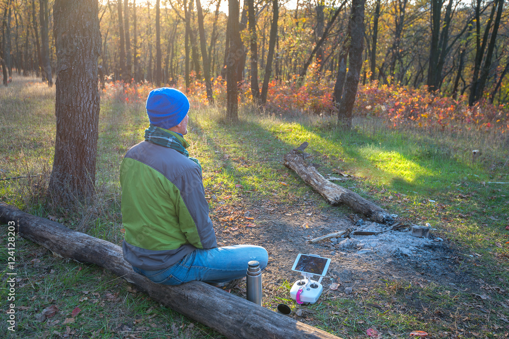 Man resting in autumn forest, after drone control Man resting in autumn forest, after drone control