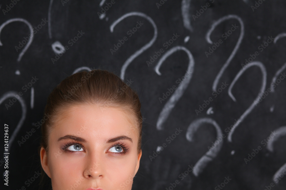 Young girl with question mark on a gray background Young girl with question mark on a gray background