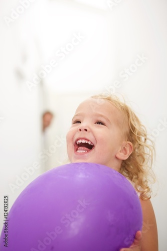Cute little girl holding balloon and laughing