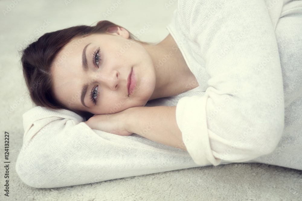 portrait of brunette woman lying on carpet portrait of brunette woman lying on carpet