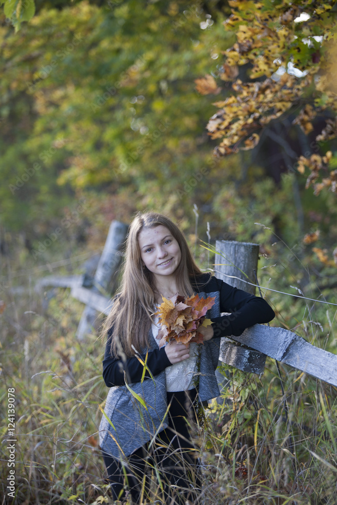Naklejka premium Dziewczyna z ślicznym uśmiechem w słoneczny jesienny dzień