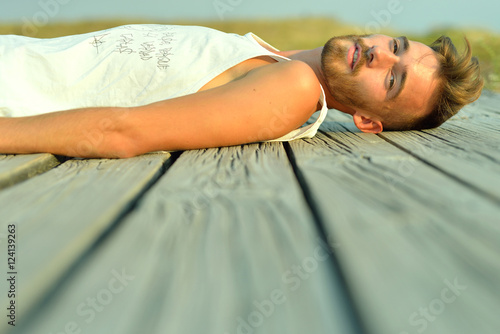 Side view of man lying on wooden boards photo