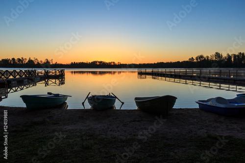 Лодки в предрассветный час на фоне озера