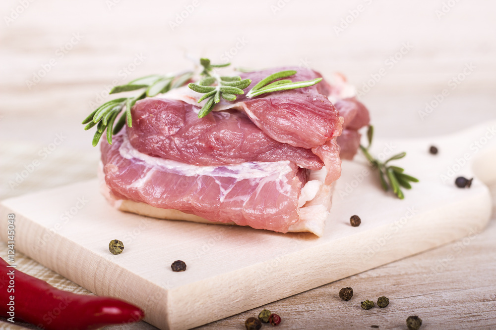Fresh meat : raw pork with red chili pepper, dill and rosemary on wooden board Fresh meat : raw pork with red chili pepper, dill and rosemary on wooden board
