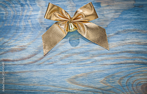 Golden Christmas bow on wooden board top view celebrations conce