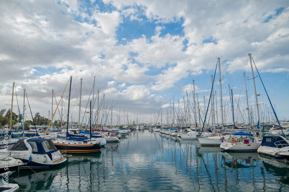 Yachts standing in two rows with the reflection in the sea in a