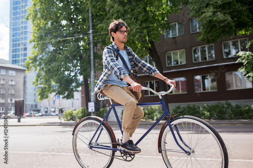 Fototapeta Naklejka Na Ścianę i Meble -  young hipster man with bag riding fixed gear bike