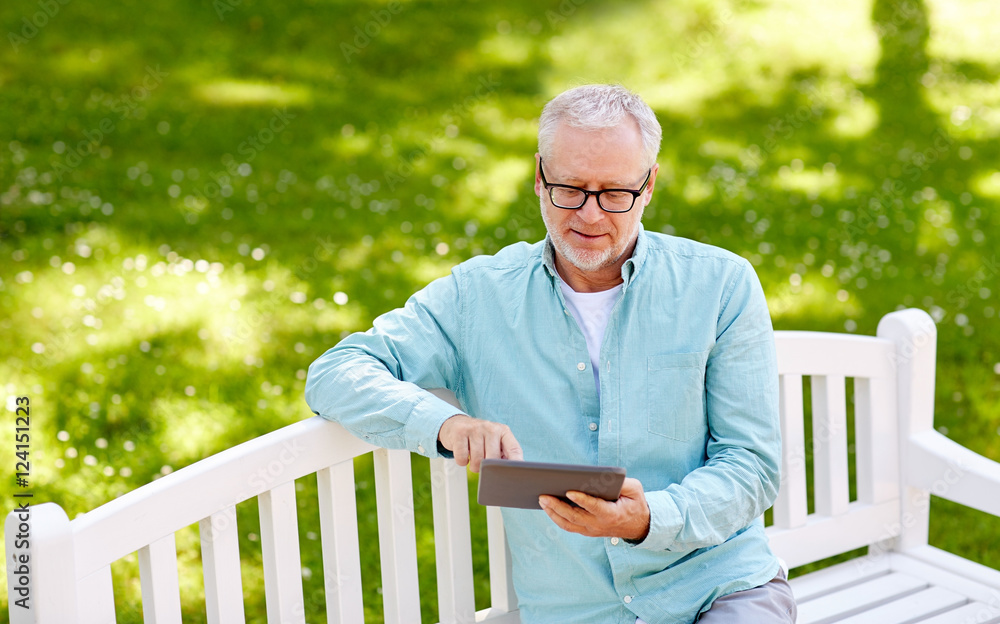 Fototapeta premium senior man with tablet pc at summer park