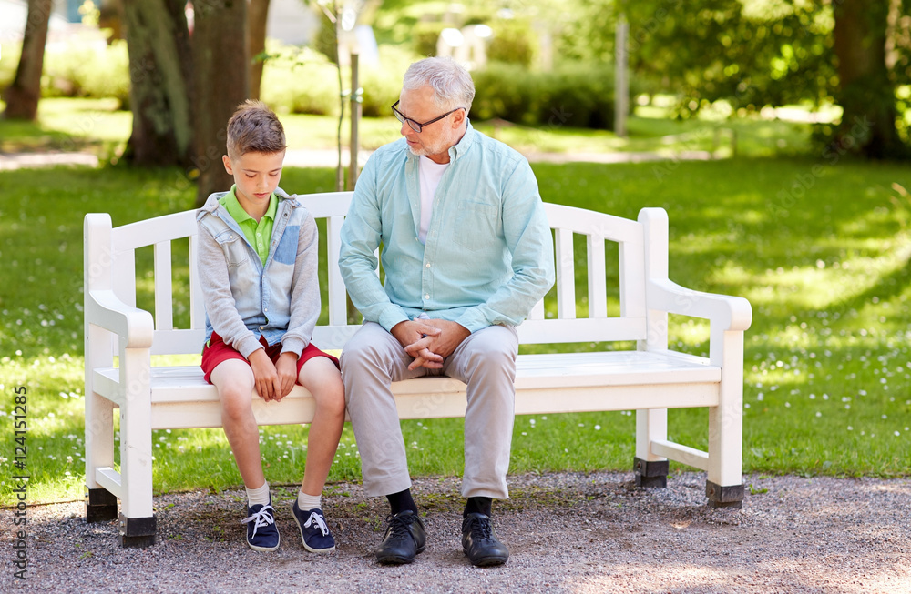grandfather and grandson talking at summer park grandfather and grandson talking at summer park