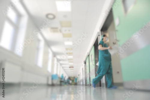 Doctors and nurses walking in hospital hallway, blurred motion.