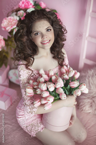 Fototapeta Naklejka Na Ścianę i Meble -  Beautiful happy smiling girl with curly hair, teen with flowers