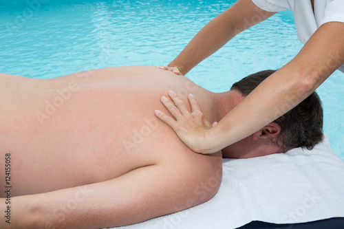 Female is massaging man at spa center