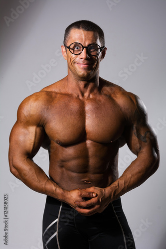 Happy muscular man with a naked torso and funny glasses