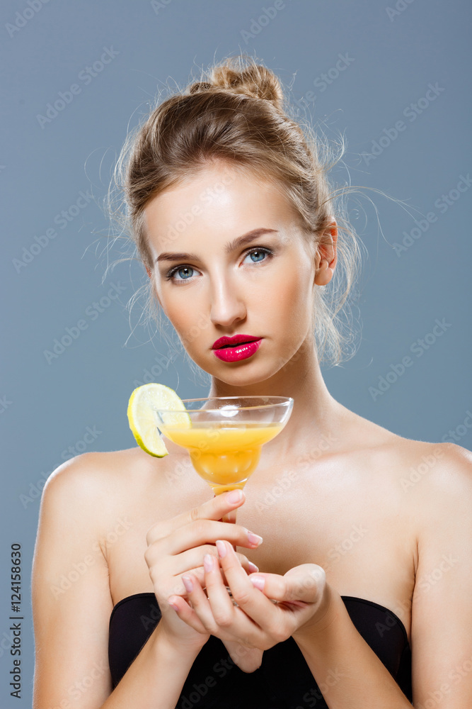 Beautiful blonde naked girl holding cocktail over grey background. Beautiful blonde naked girl holding cocktail over grey background.