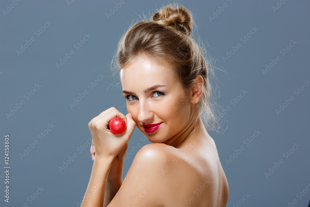 Young beautiful blonde girl holding chupa chups over grey background. Young beautiful blonde girl holding chupa chups over grey background.