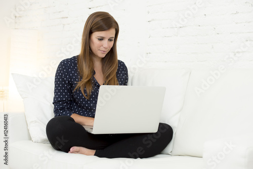 happy beautiful 30s woman using laptop computer smiling networking at home modern living room relaxed
