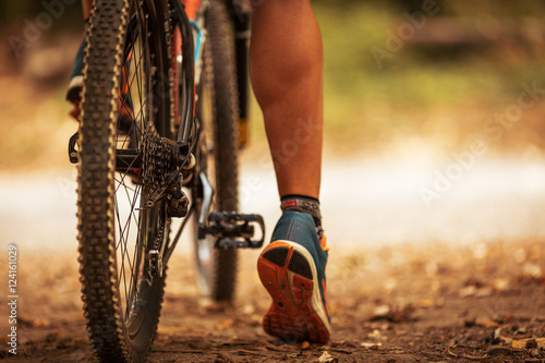 Fototapeta Naklejka Na Ścianę i Meble -  Rear view of mountain bike and man's legs.