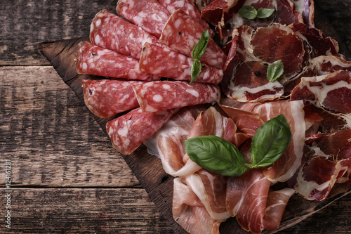 Traditional spanish tapas or italian antipasti on wooden vintage table photo