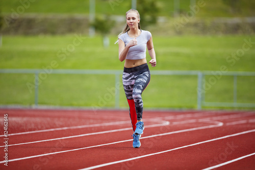 Woman In Sportswear Running On Sports Track